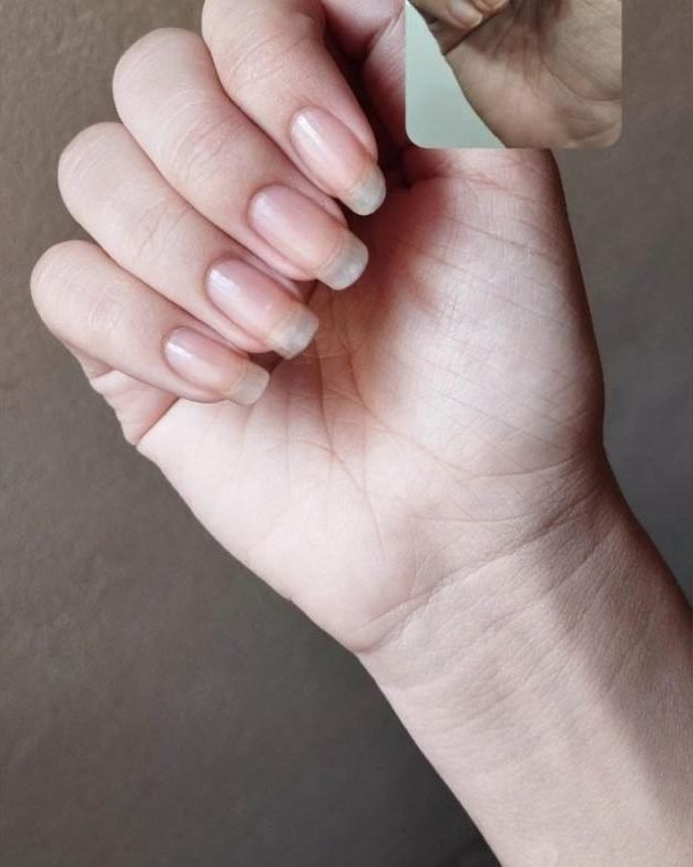 Mão de cliente com unhas naturais longas